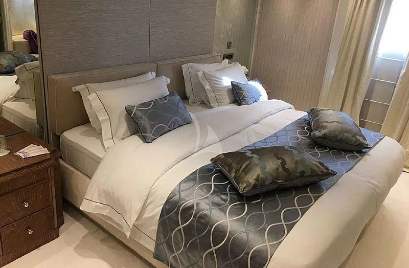 a bed with a blue and white comforter and pillows aboard ELEGANT 007 Yacht for Sale