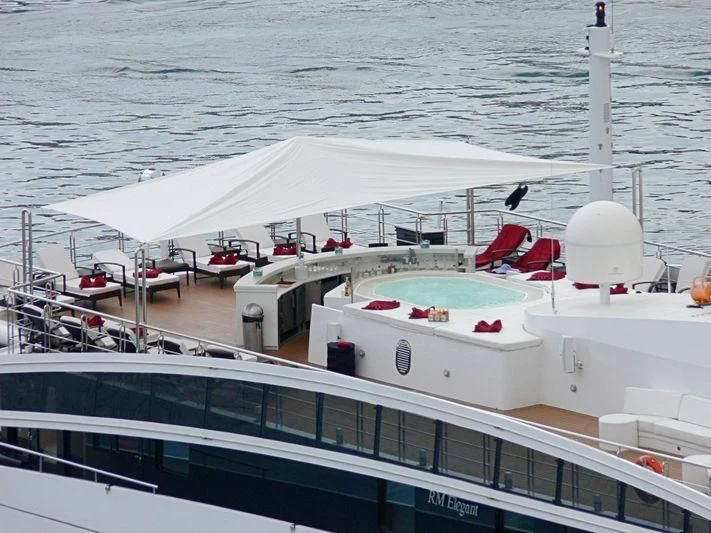 a large white boat with red seats aboard ELEGANT 007 Yacht for Sale