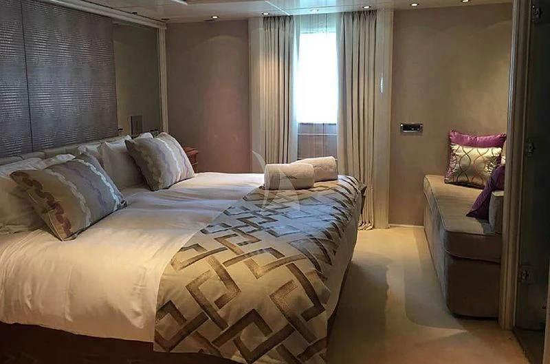a bedroom with a bed and a chair aboard ELEGANT 007 Yacht for Sale