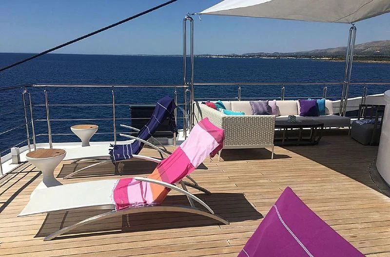 a deck with a chair and a table on it aboard ELEGANT 007 Yacht for Sale