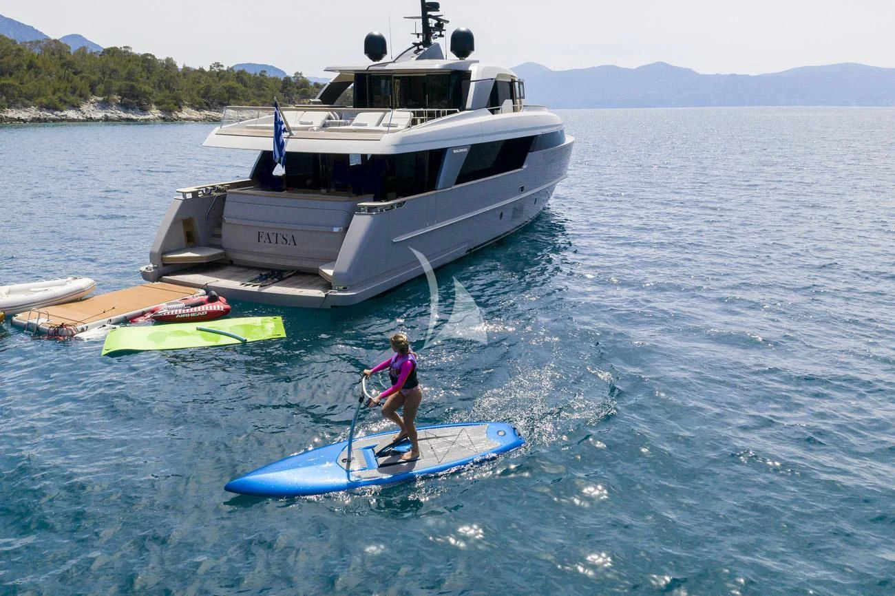 a person on a paddle board next to a boat aboard FATSA Yacht for Sale