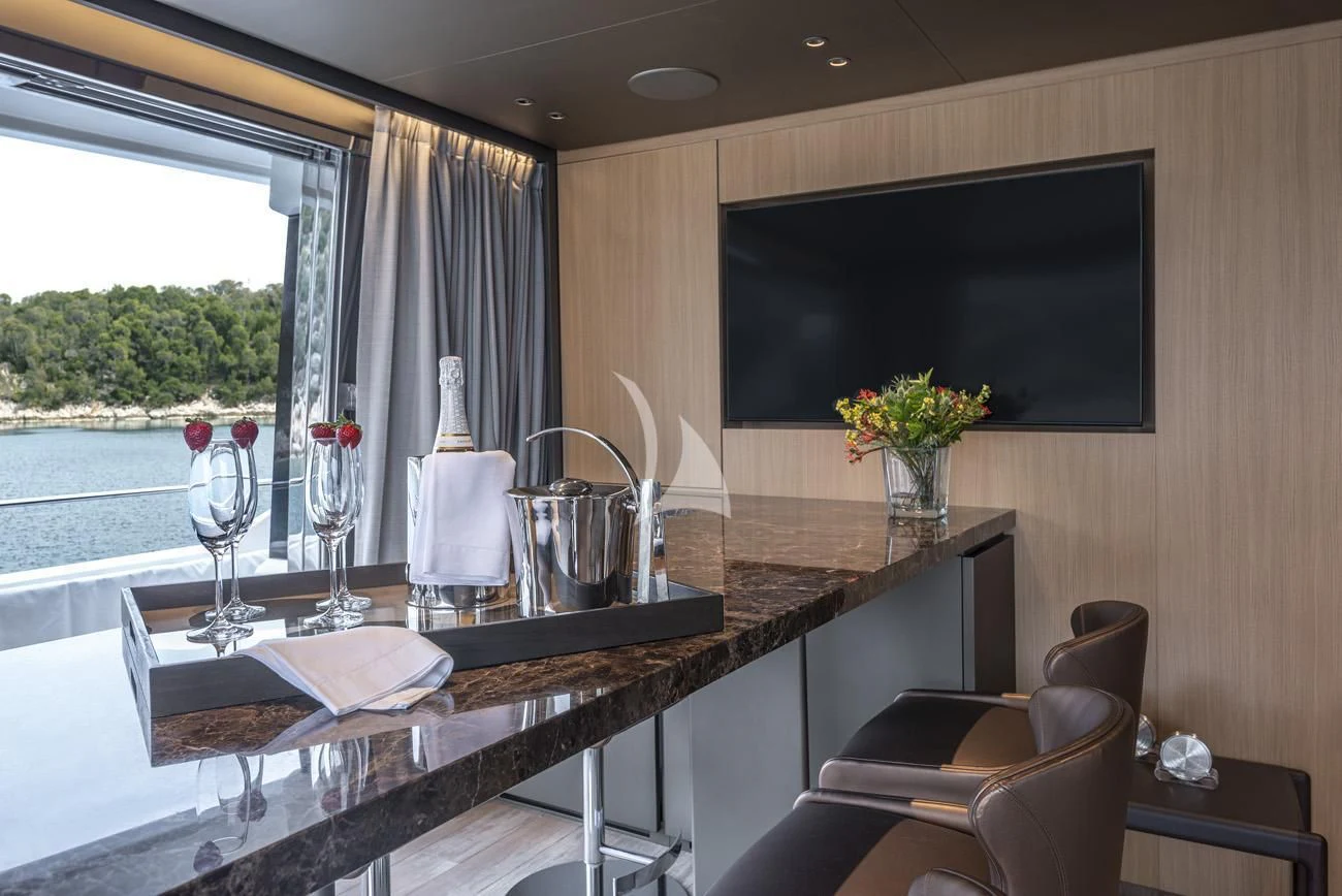 a table with wine glasses and a television on it aboard FATSA Yacht for Sale