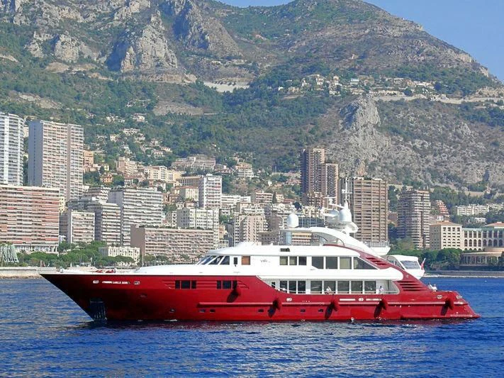 a red and white boat on water with a city in the background aboard LEDRA Yacht for Sale