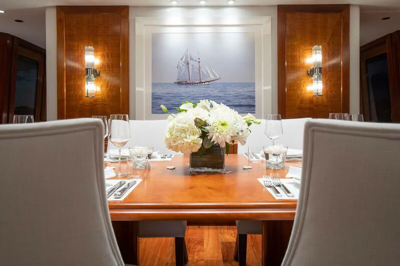 a table with wine glasses and flowers aboard BRAVEHEART Yacht for Sale