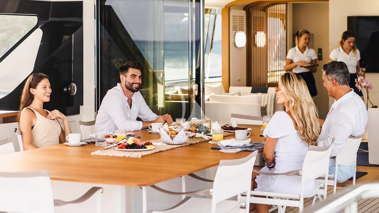 a group of people around a table aboard KOJU Yacht for Sale