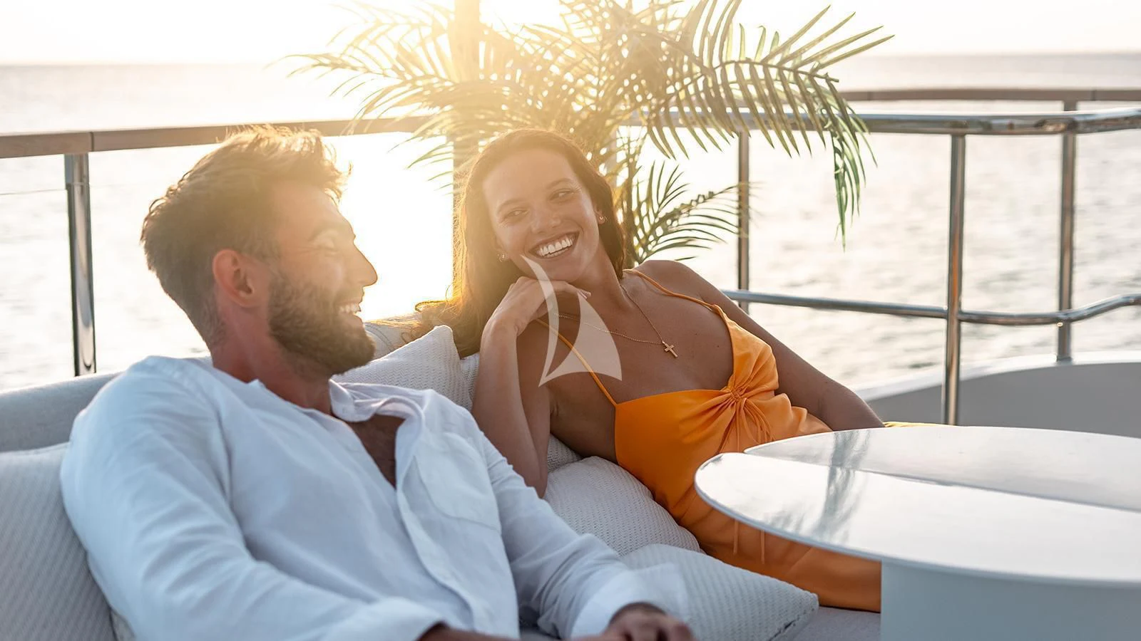 a man and woman sitting on a couch aboard KOJU Yacht for Sale