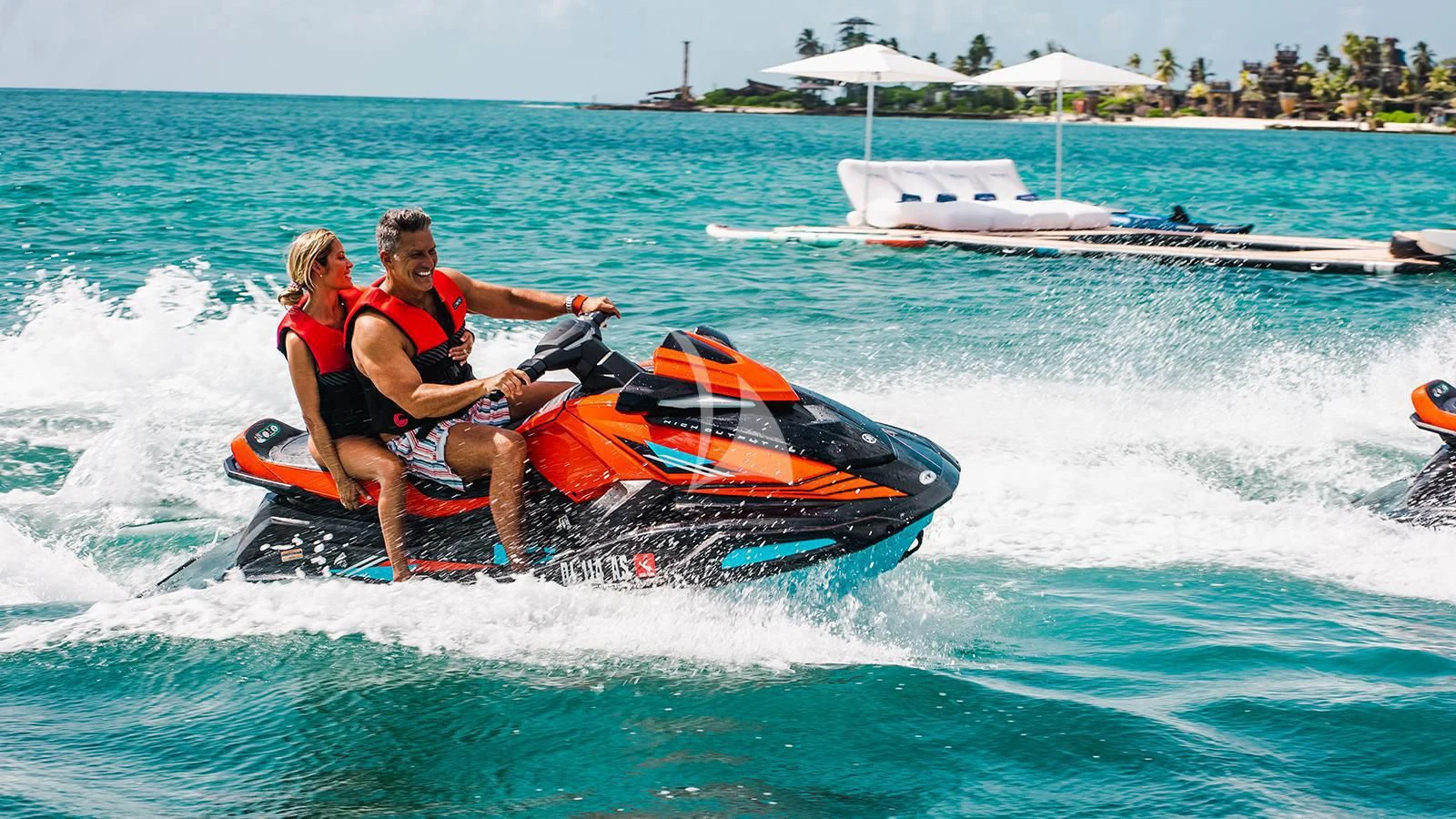 a man and woman riding a jet ski in the ocean aboard KOJU Yacht for Sale