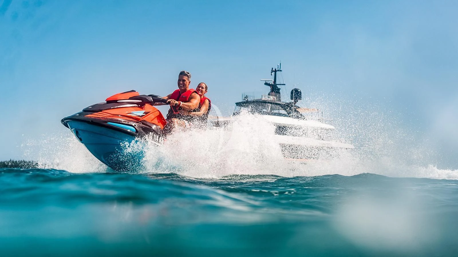 a man and a woman riding a boat in the ocean aboard KOJU Yacht for Sale