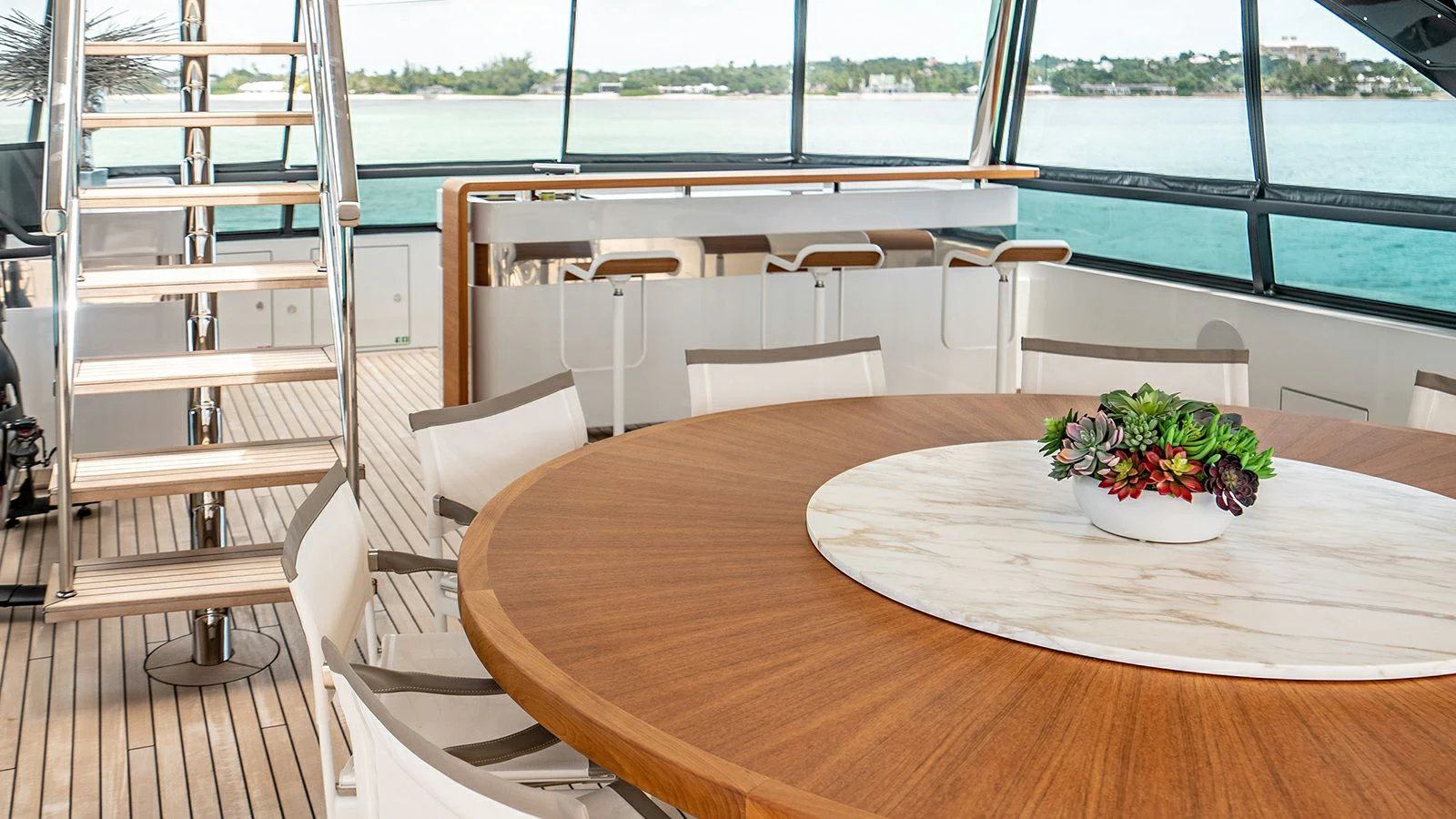 a table with chairs and a plant on it aboard KOJU Yacht for Sale