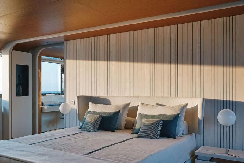 a bed with a white sheet and pillows aboard KOJU Yacht for Sale