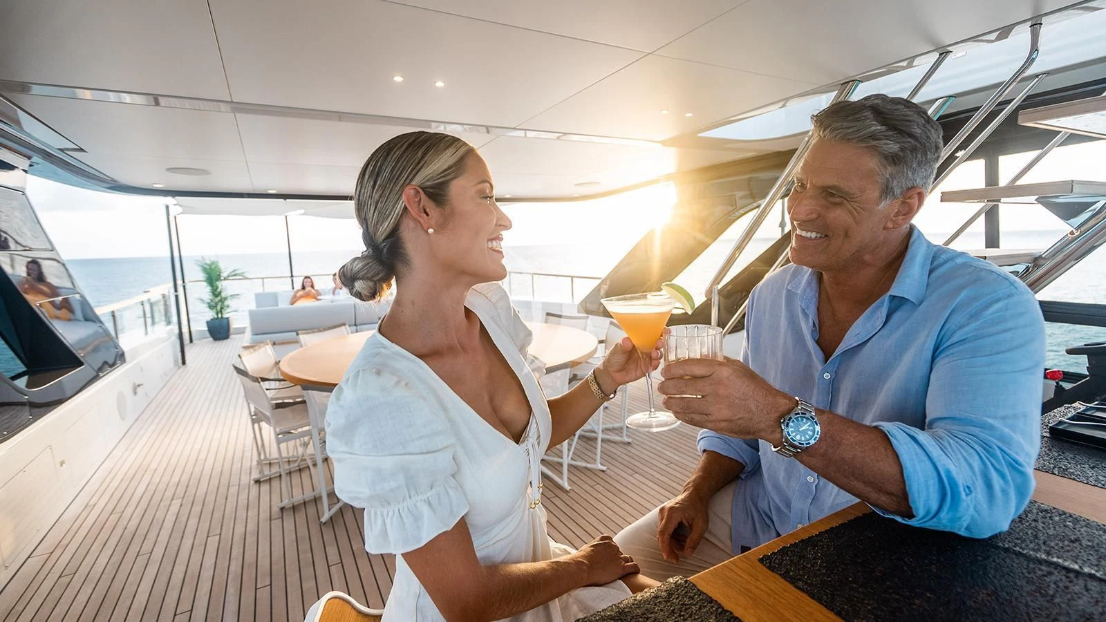 a man and a woman holding glasses of wine aboard KOJU Yacht for Sale