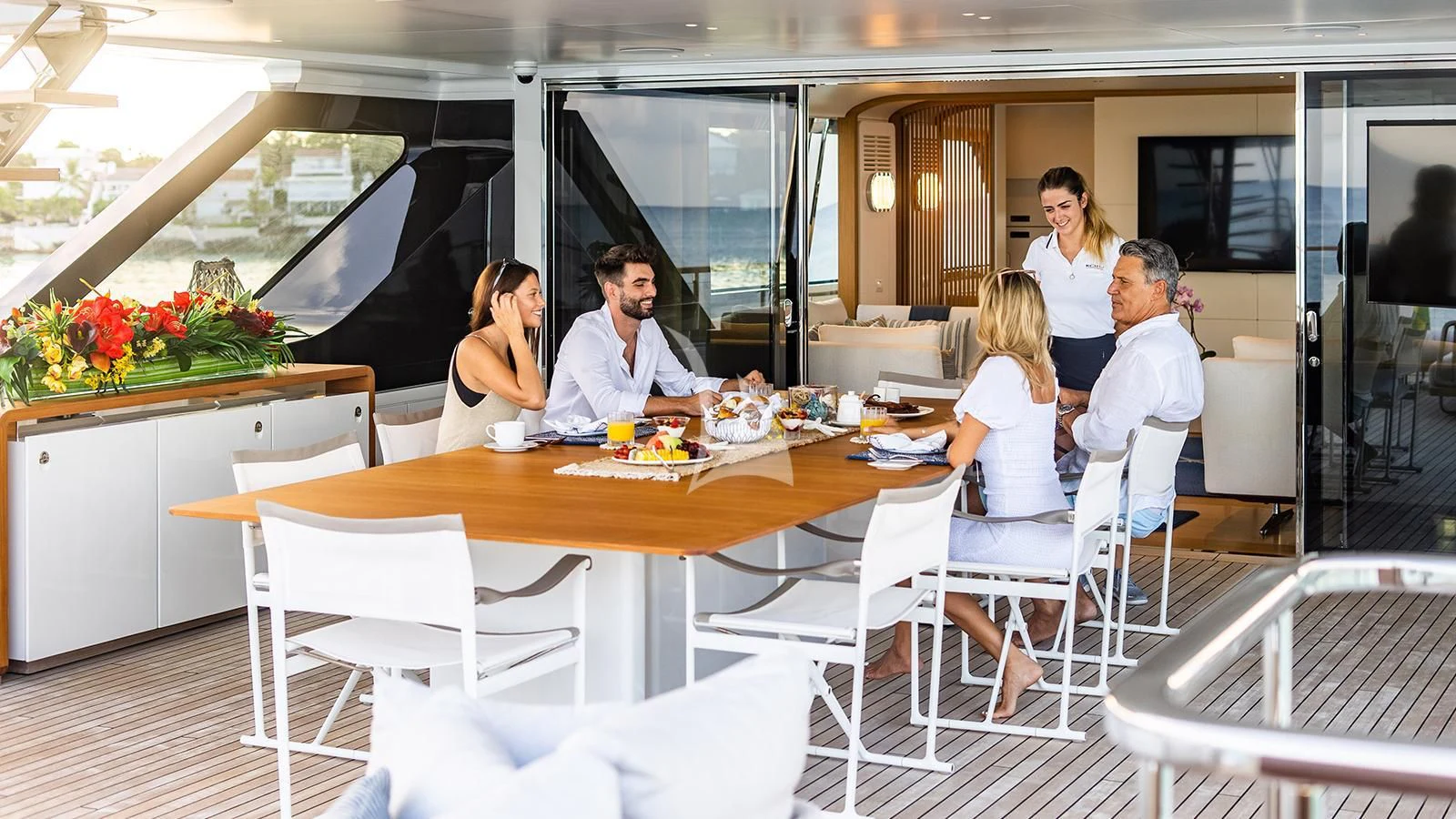 a group of people sitting around a table aboard KOJU Yacht for Sale