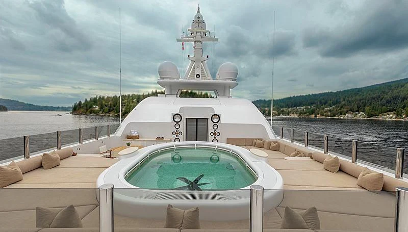 a white boat with a blue water fountain in the middle aboard KOJU Yacht for Sale