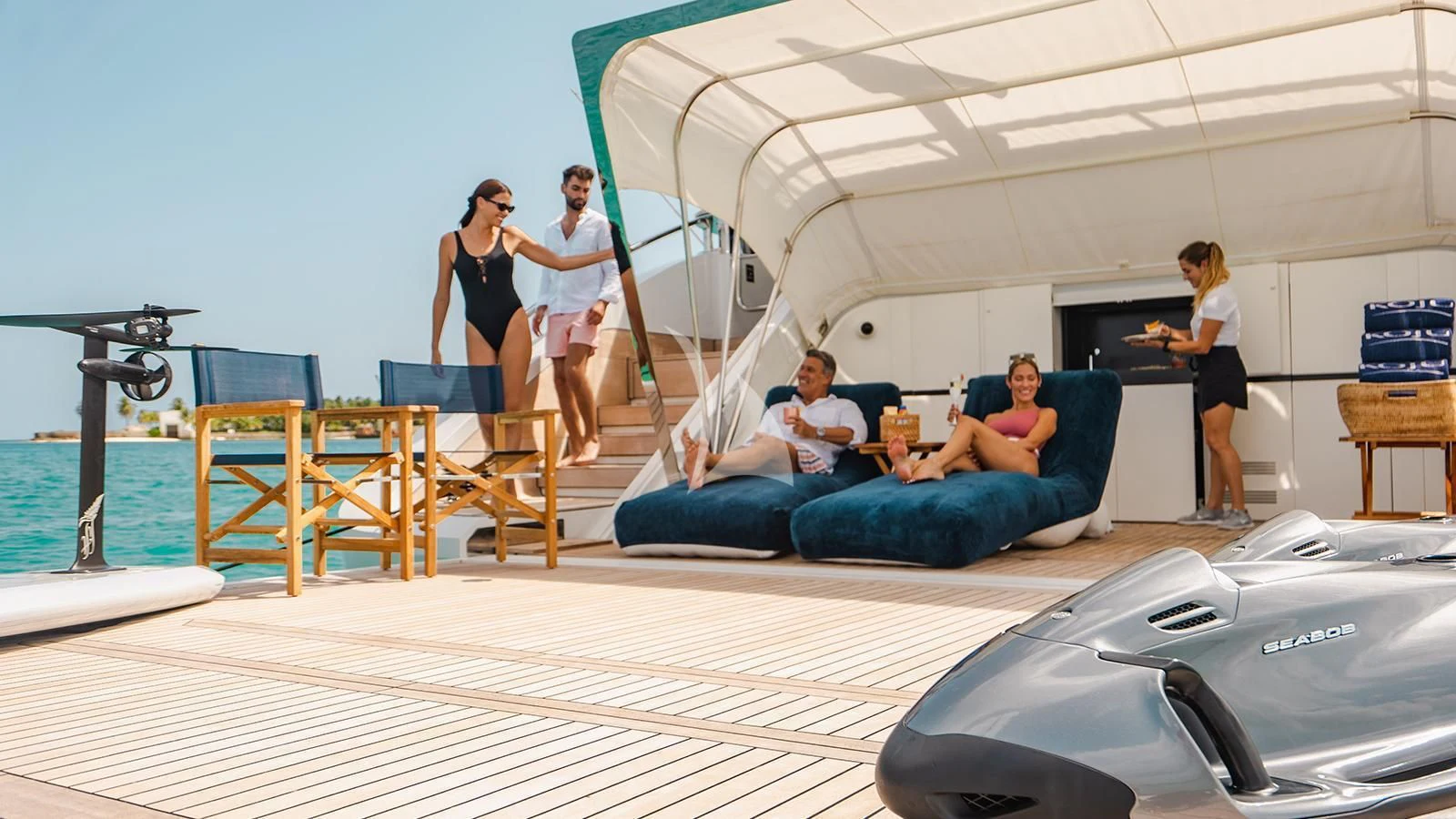 a group of people in a lounge aboard KOJU Yacht for Sale