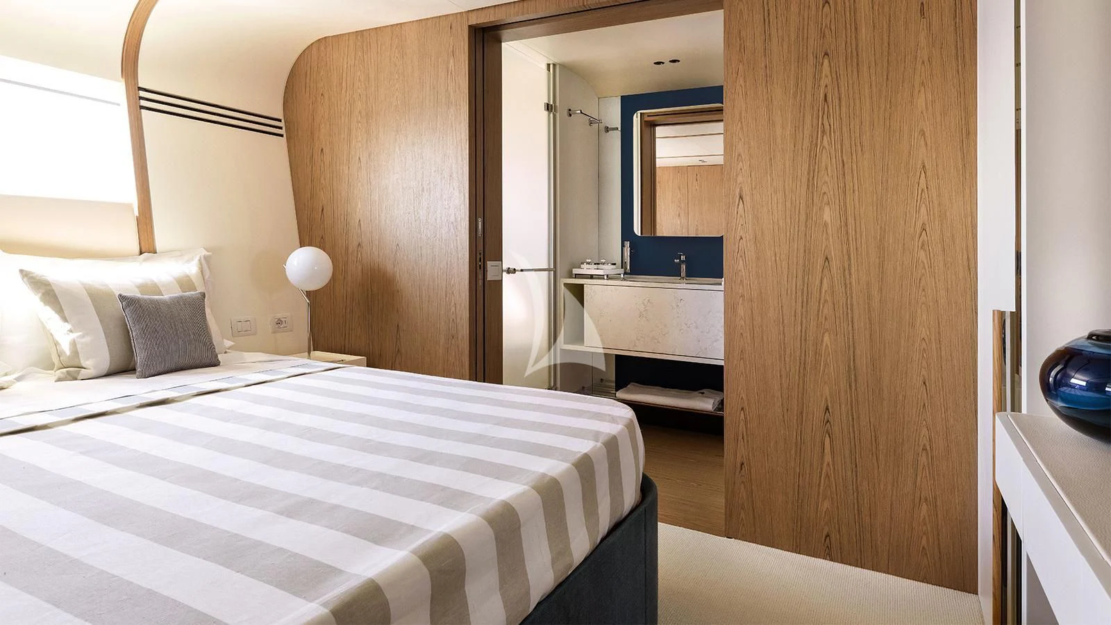 a bedroom with a bed and a wood door aboard KOJU Yacht for Sale
