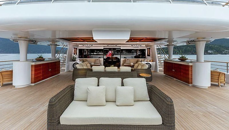 a living room with a large white sofa and a red table aboard KOJU Yacht for Sale