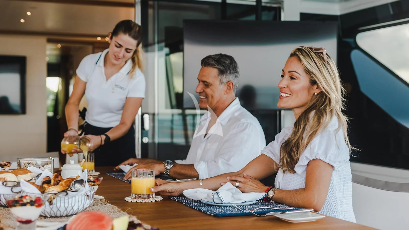 a group of people sitting at a table aboard KOJU Yacht for Sale