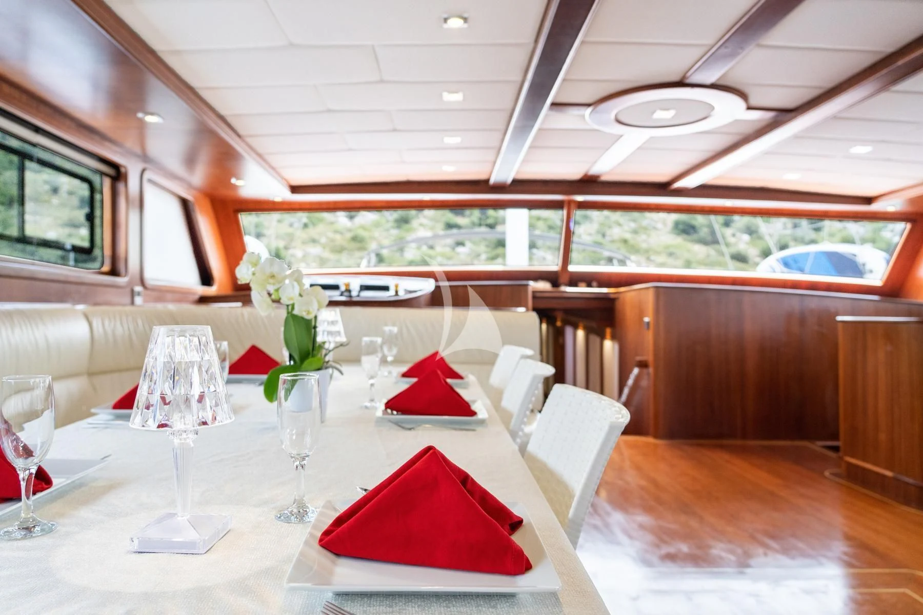 a table with red napkins and glasses on it aboard QUESTA VITA Yacht for Sale