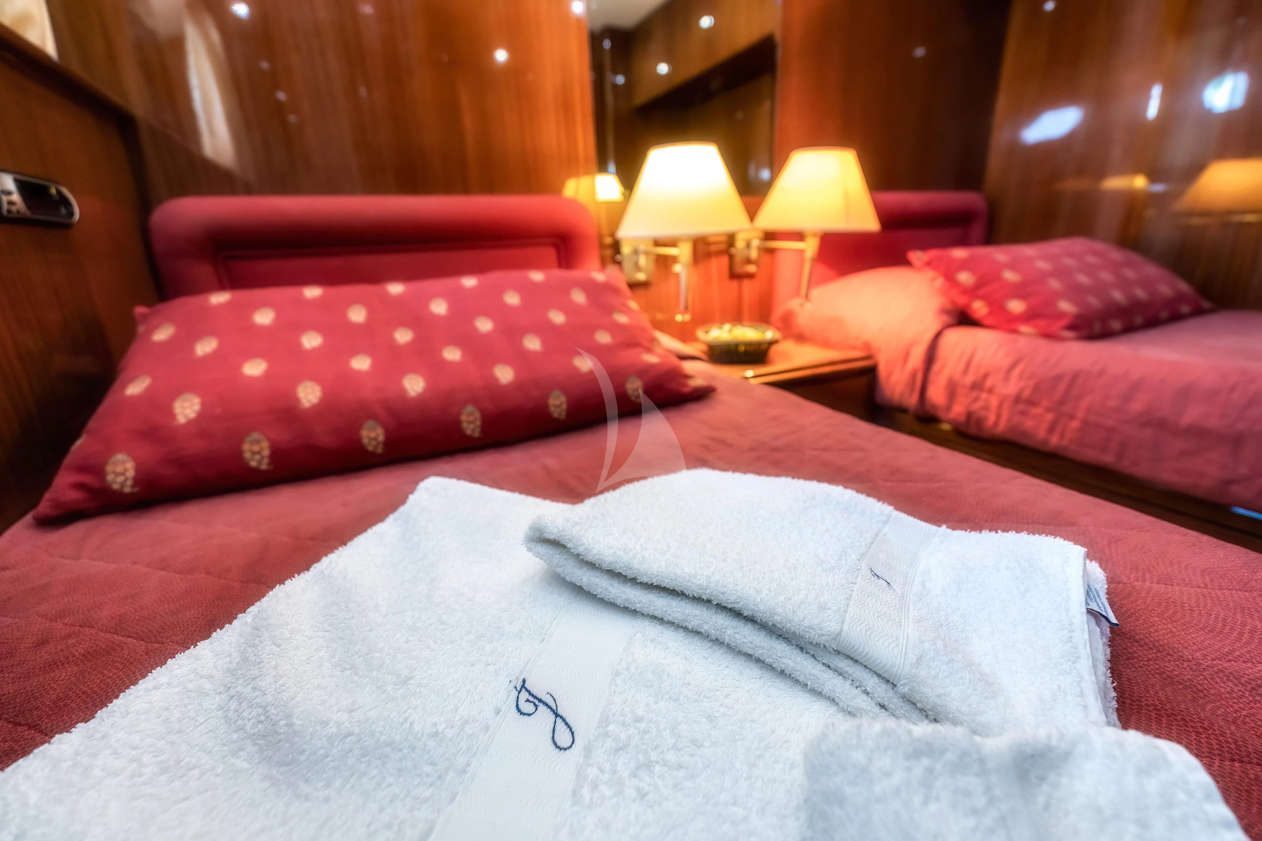 a bed with red pillows aboard JAUNI Yacht for Sale