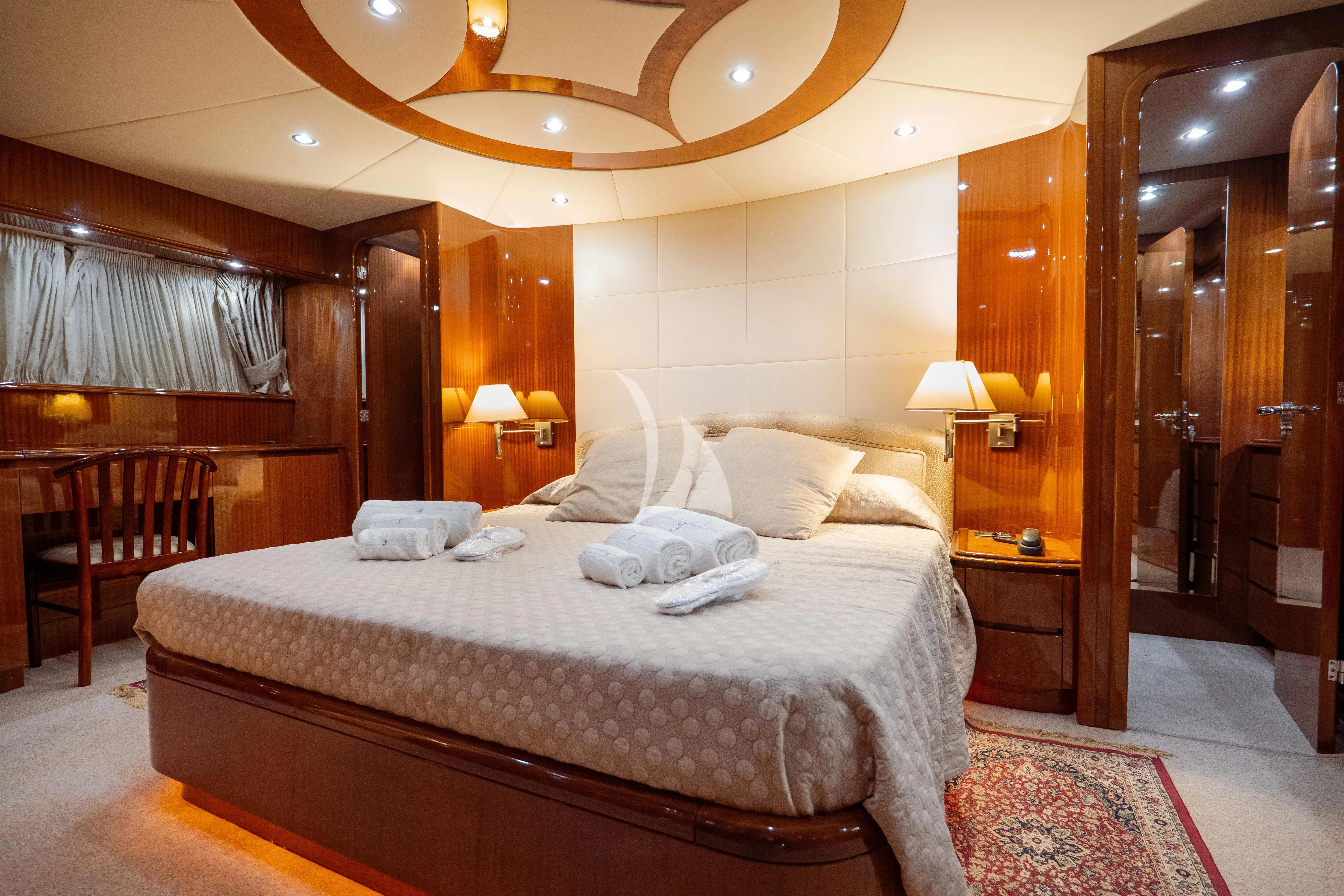 a hotel room with a bed and a chandelier aboard JAUNI Yacht for Sale