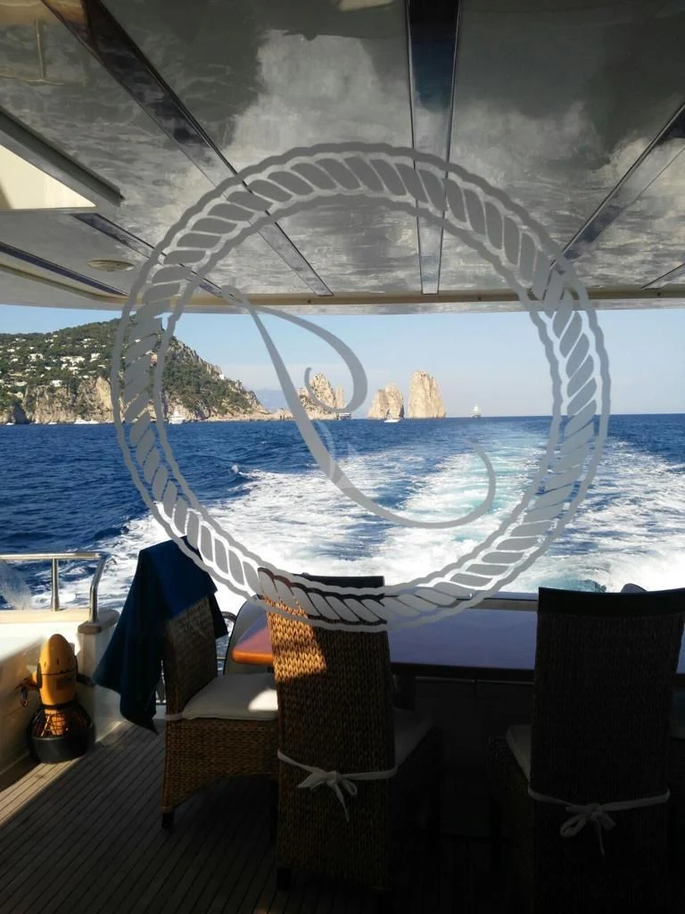 a table with chairs and a large glass dome with a view of the ocean and mountains in the aboard JAUNI Yacht for Sale