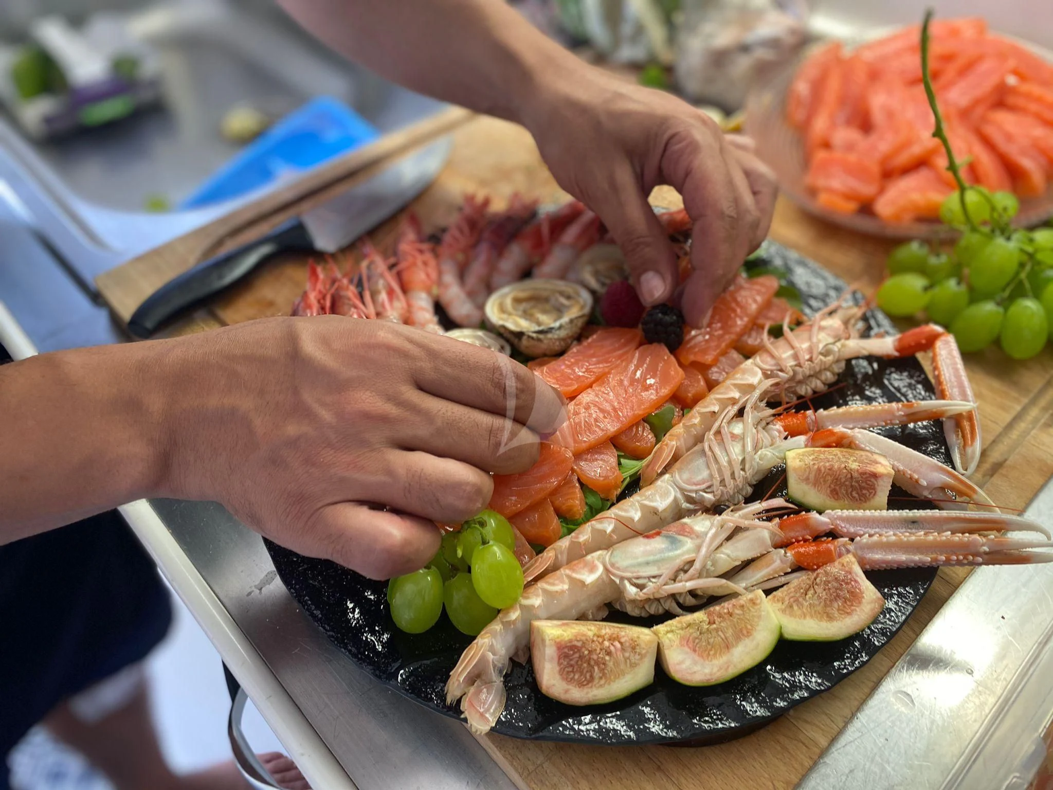 a person cutting a meat on a cutting board aboard JAUNI Yacht for Sale
