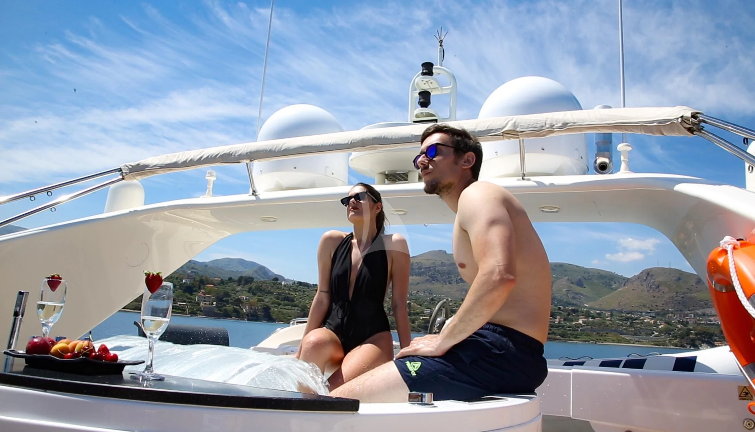 a man and woman sitting on a boat with a glass of wine aboard JAUNI Yacht for Sale