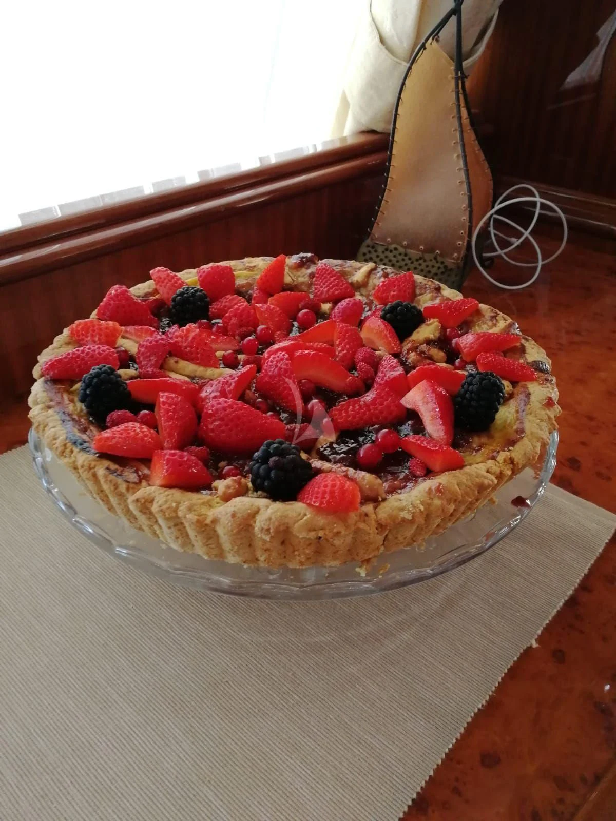 a cake with strawberries and blueberries on top aboard JAUNI Yacht for Sale