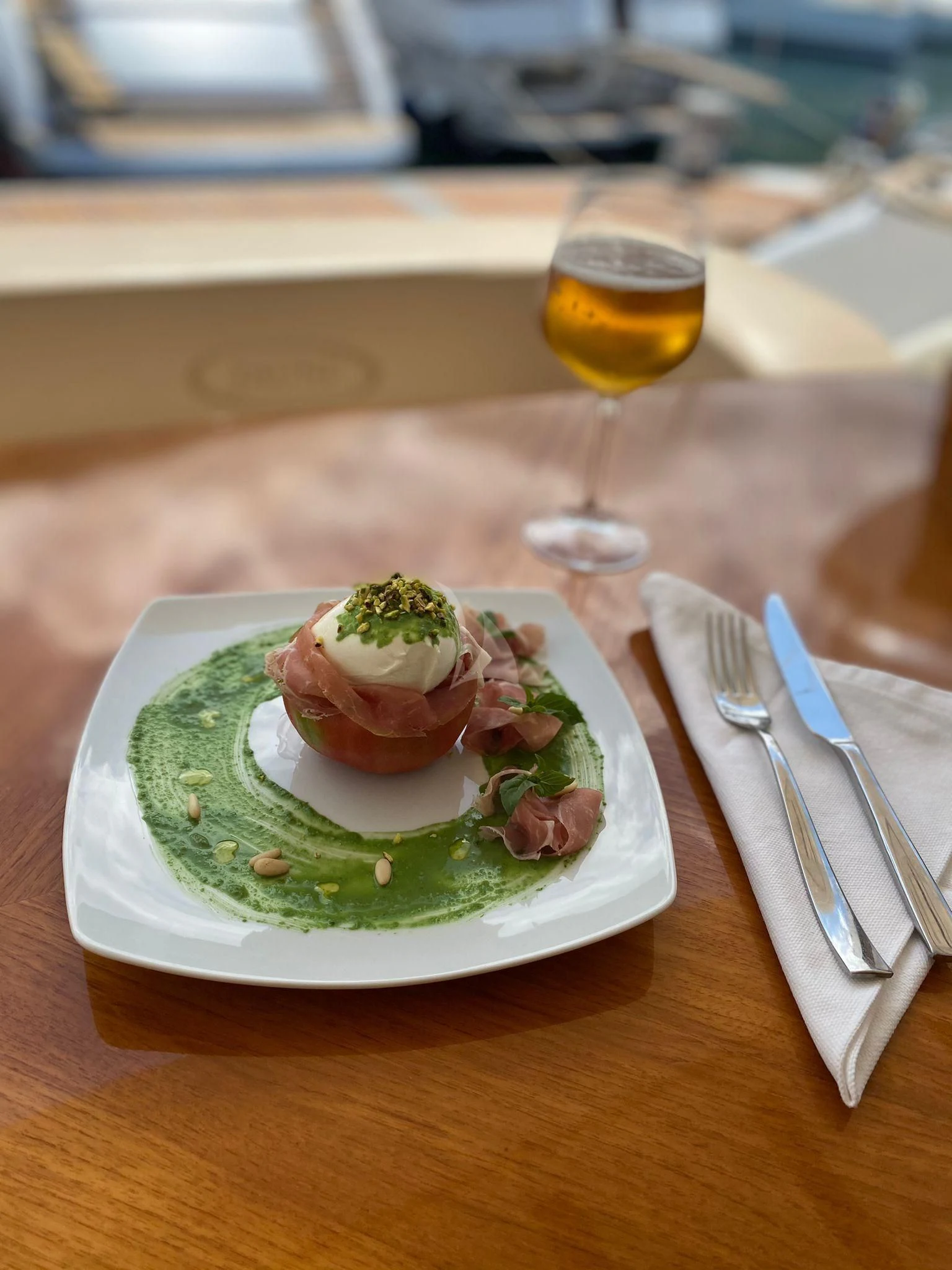 a plate of food and a glass of beer on a table aboard JAUNI Yacht for Sale