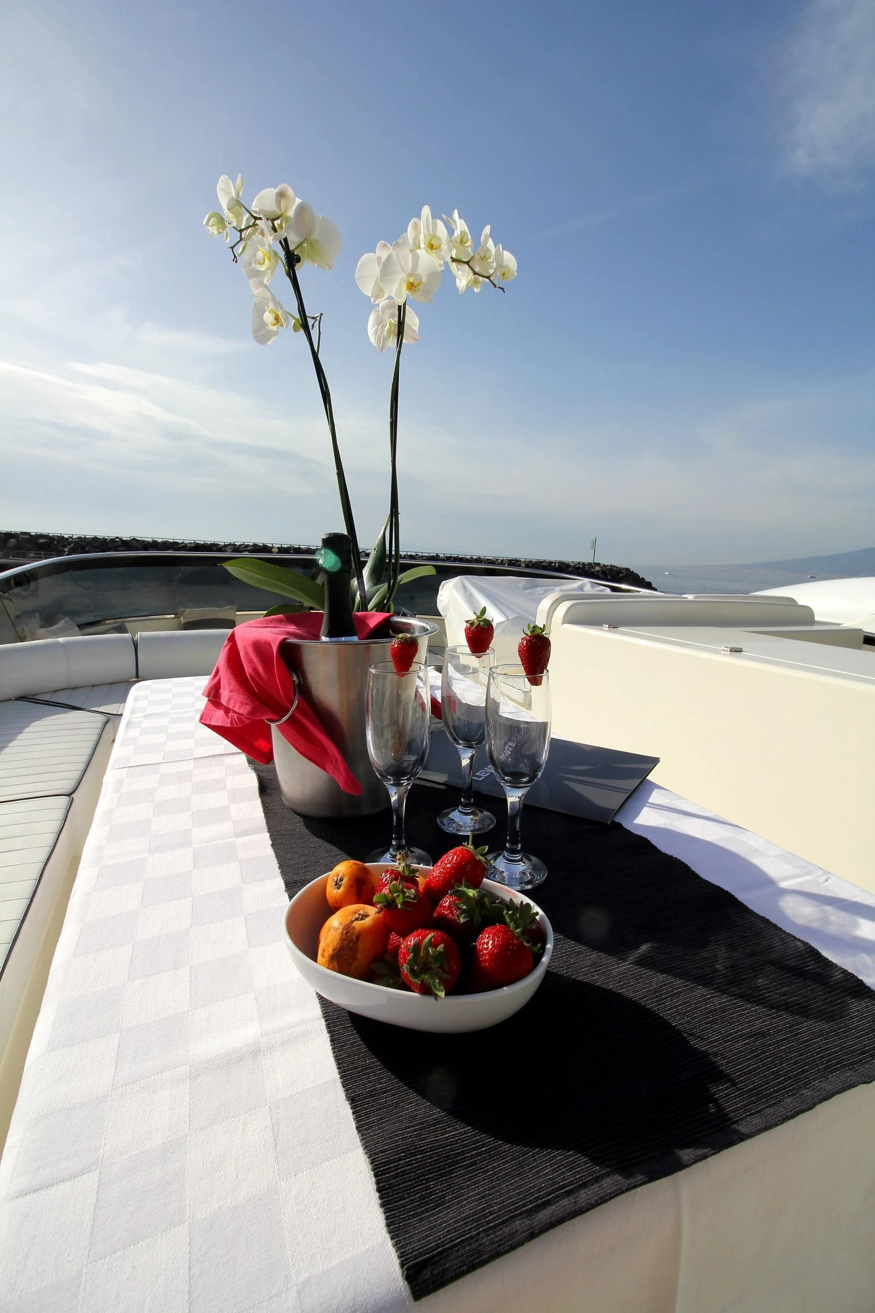 a table with glasses and a vase with flowers on it aboard JAUNI Yacht for Sale