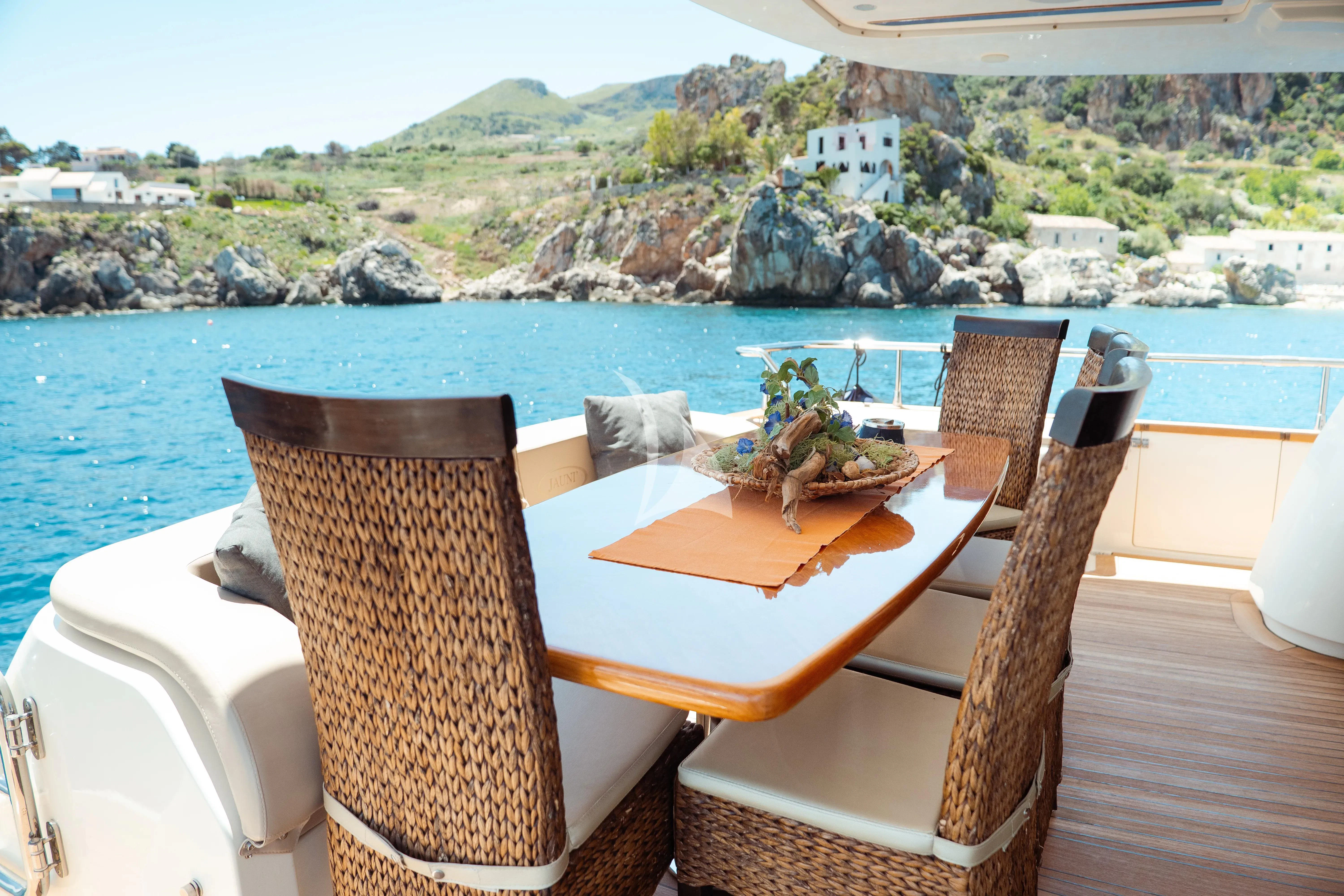 a table with chairs on it next to a body of water aboard JAUNI Yacht for Sale