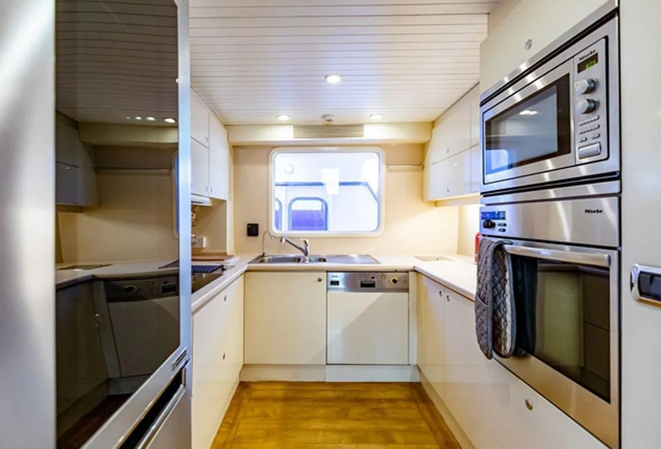 a kitchen with white cabinets aboard HISTORY Yacht for Sale