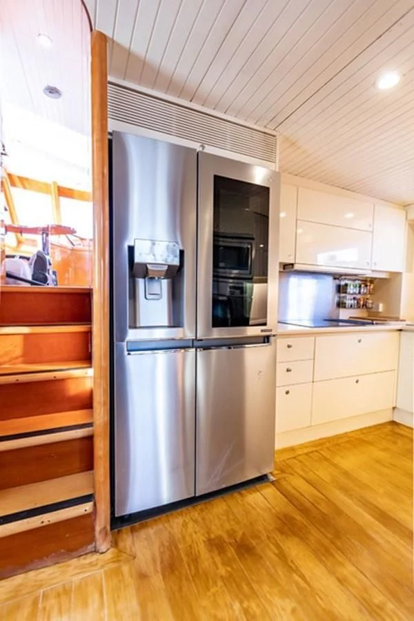 a kitchen with a stainless steel refrigerator aboard HISTORY Yacht for Sale