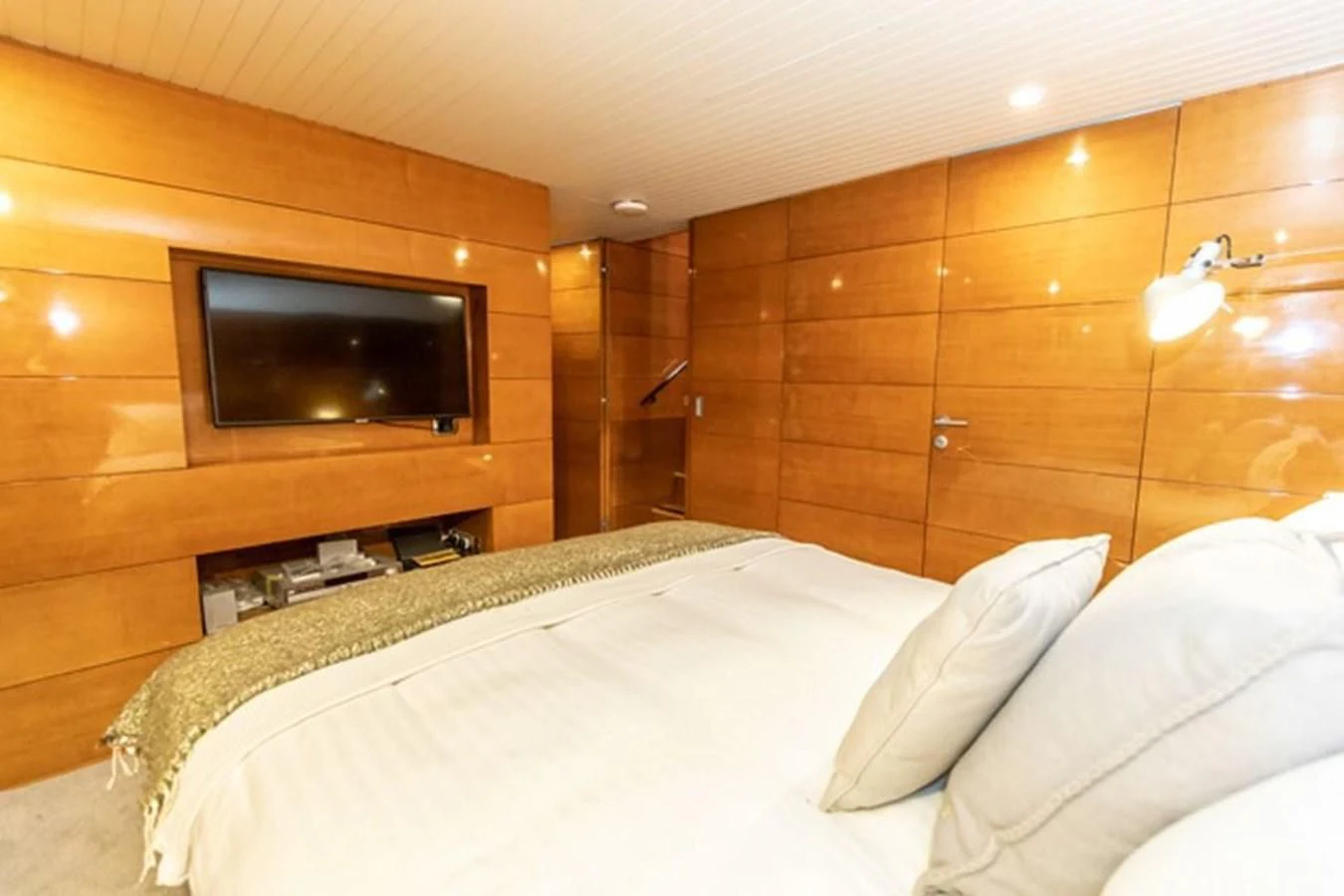 a bed with a television on the wall aboard HISTORY Yacht for Sale