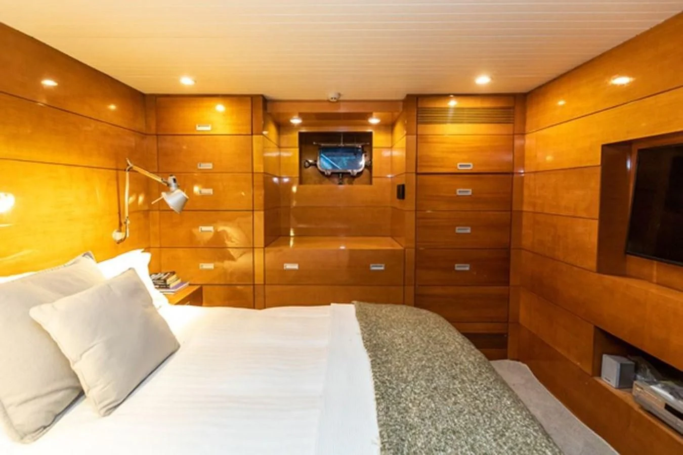 a bed with a white sheet and a wooden wall aboard HISTORY Yacht for Sale