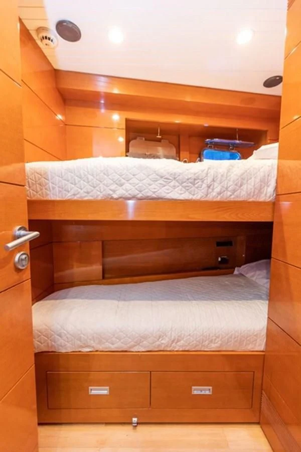 a bed with a wooden headboard aboard HISTORY Yacht for Sale