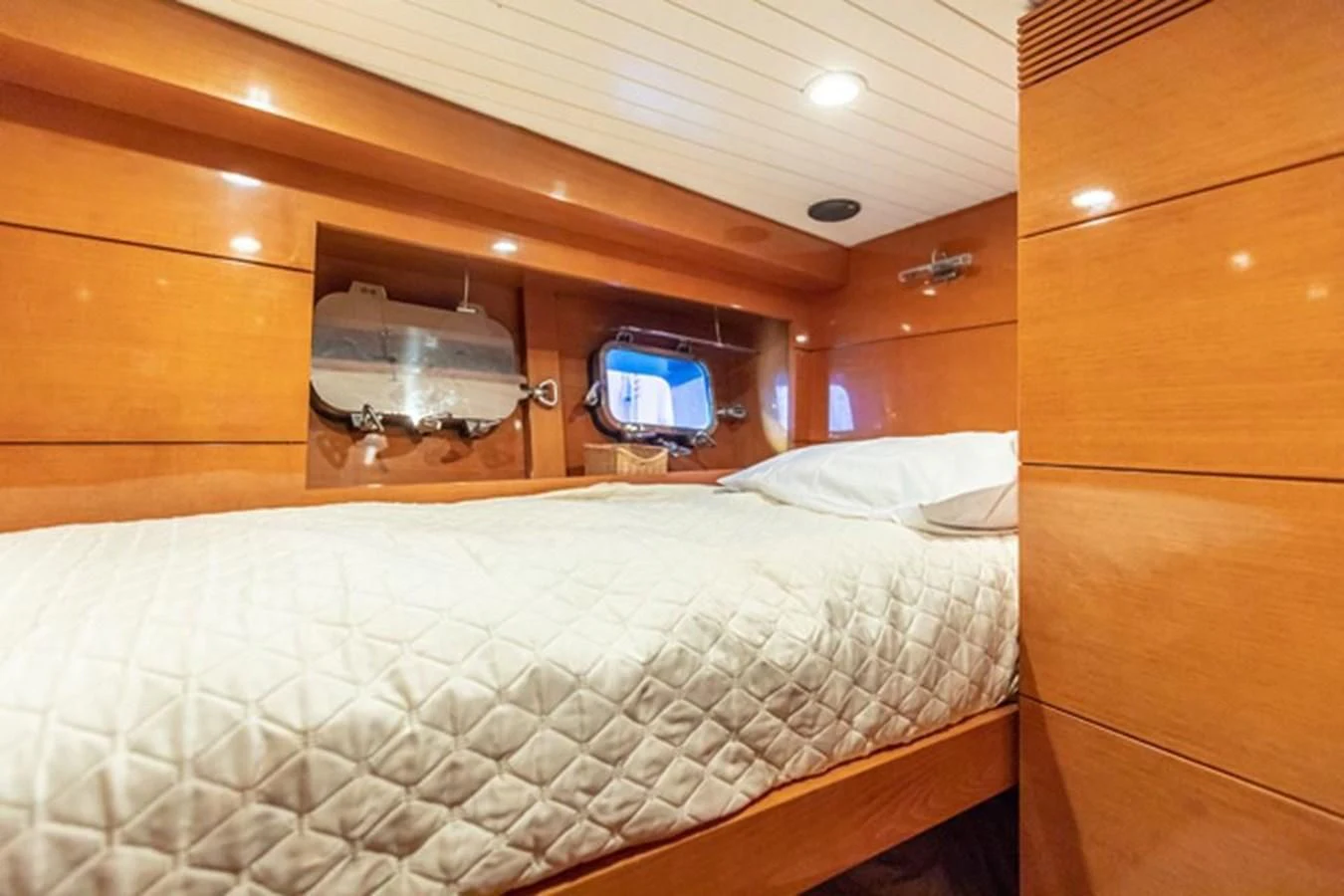 a bed with a television on the wall aboard HISTORY Yacht for Sale