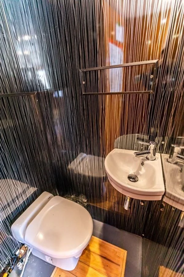 a bathroom with a toilet and sink aboard HISTORY Yacht for Sale
