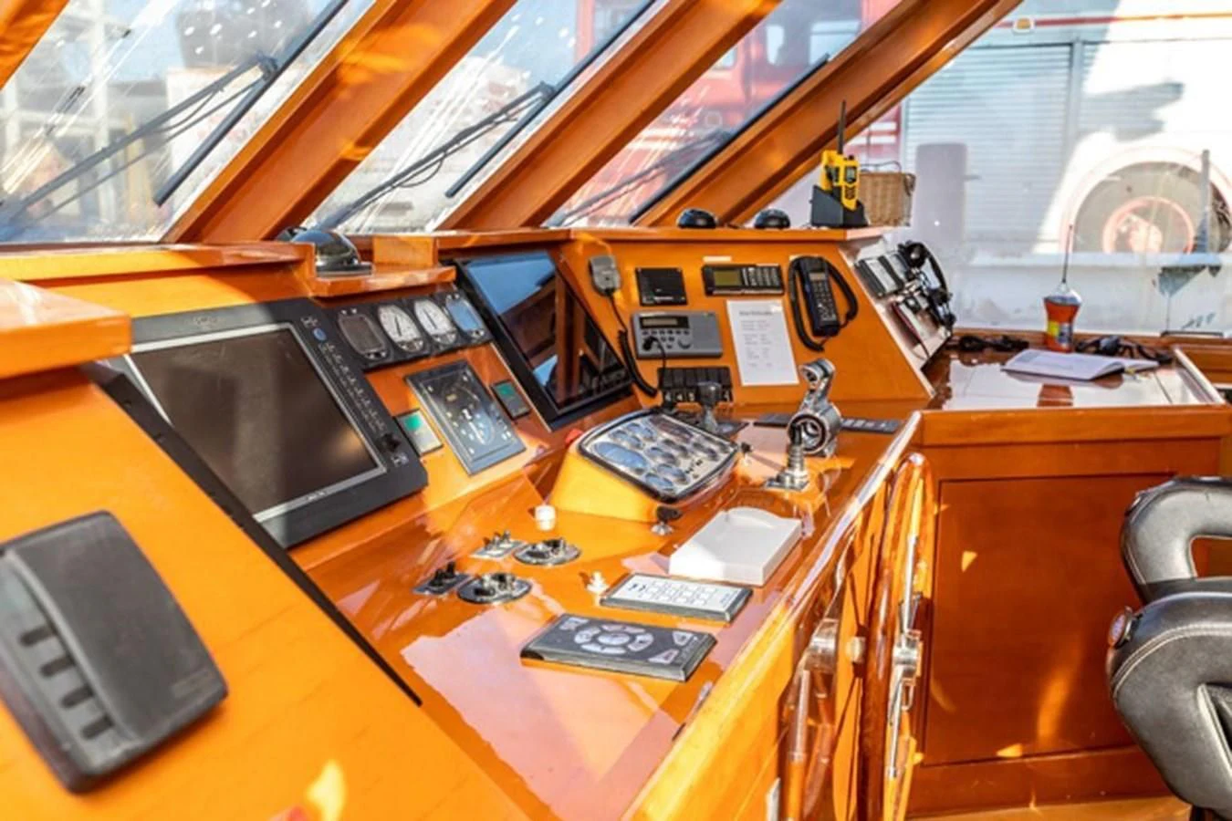 a wooden desk with a computer and other electronics on it aboard HISTORY Yacht for Sale