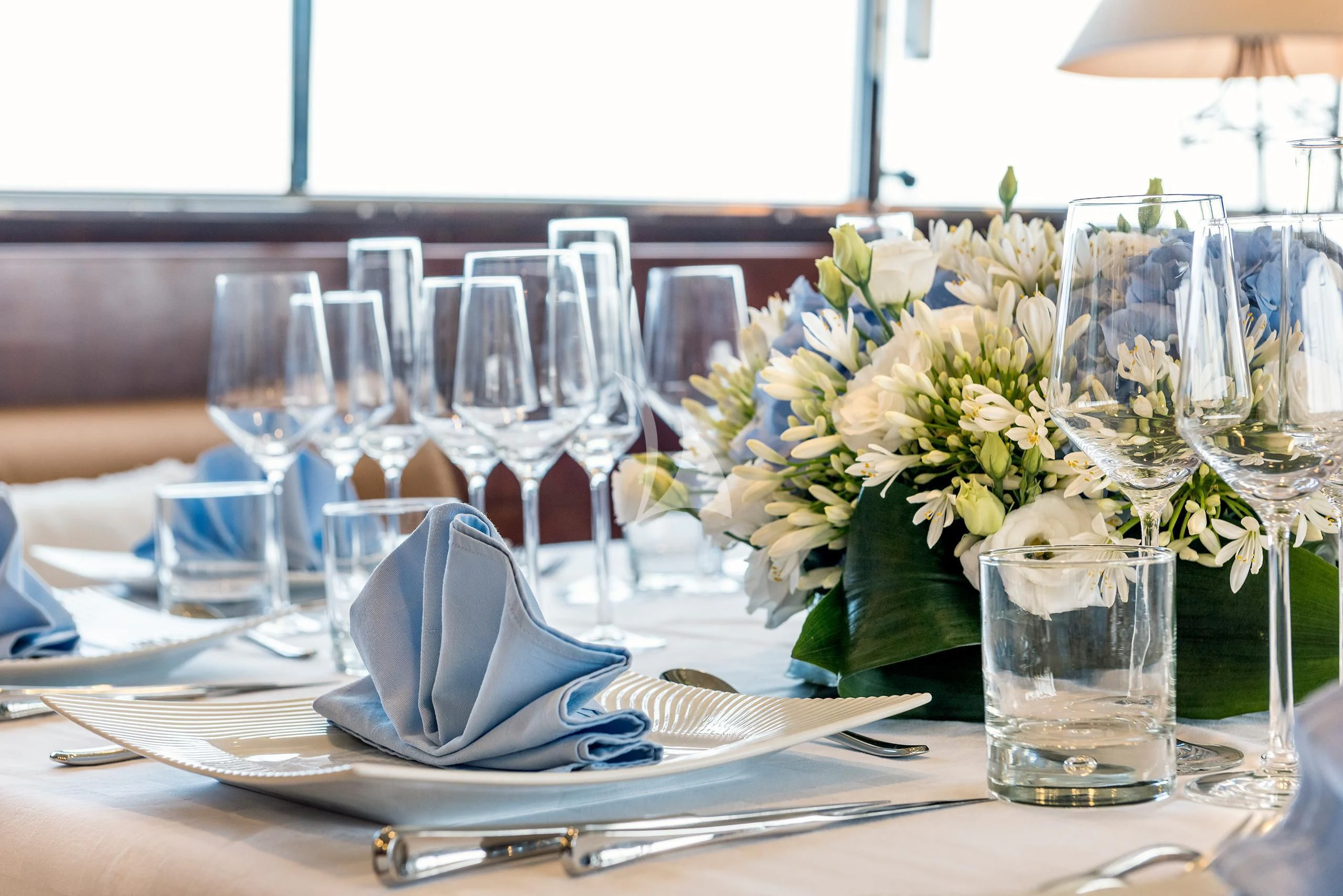 a table with a vase of flowers and glasses on it aboard ANTISAN Yacht for Charter
