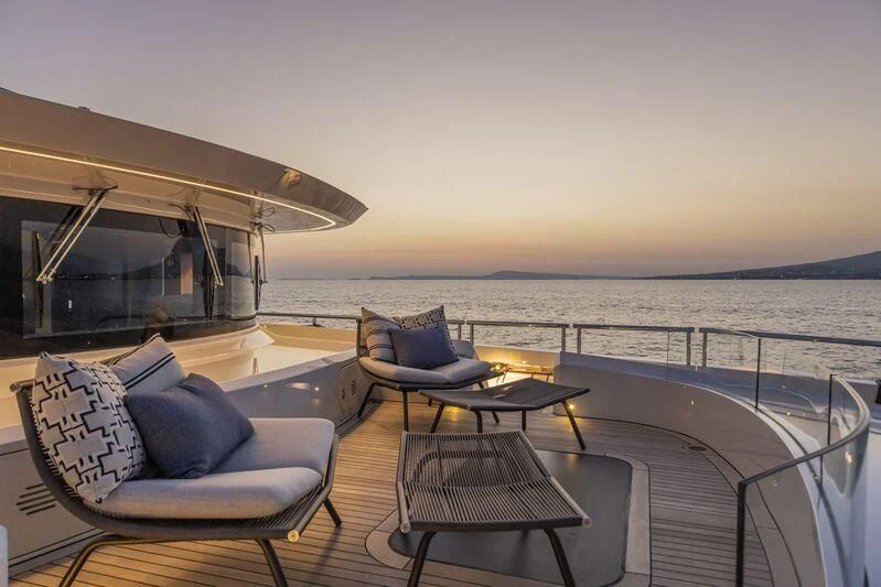 a deck with a table and chairs on it aboard ARIA SF Yacht for Sale