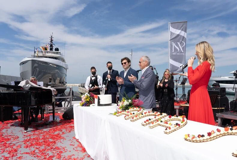 a group of people standing around a table with a cake and a flag aboard ARIA SF Yacht for Sale