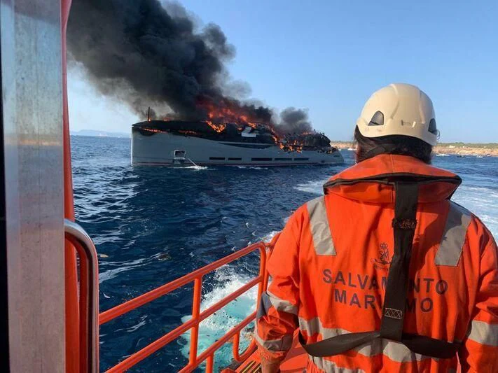 a man on a boat with a fire in the background aboard ARIA SF Yacht for Sale