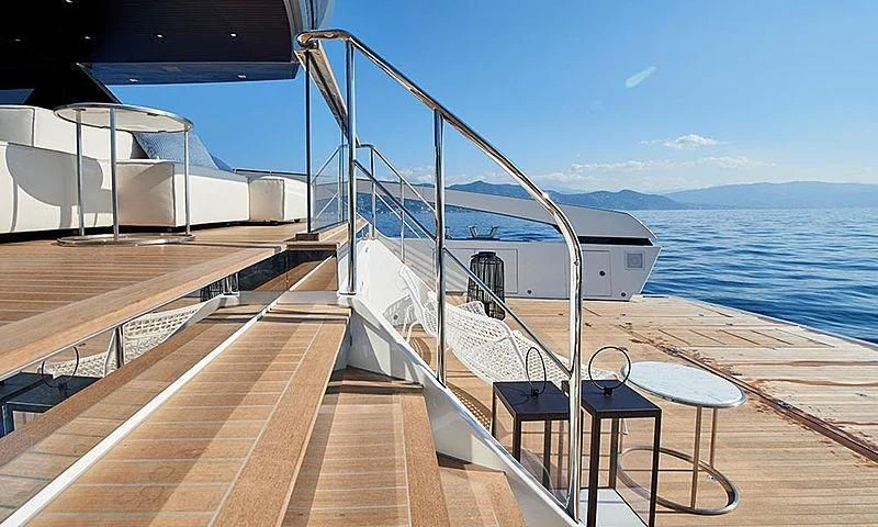 a deck with a railing and a body of water in the background aboard VICKY Yacht for Sale