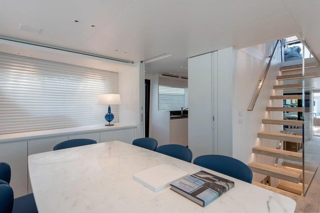 a white table with a lamp on it and a book on it aboard VICKY Yacht for Sale