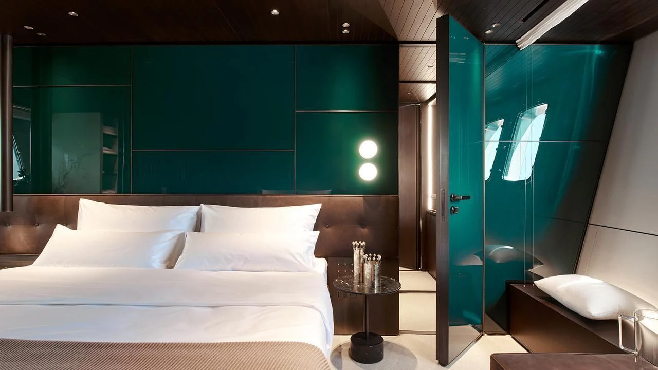 a bed with a blue wall aboard VICKY Yacht for Sale