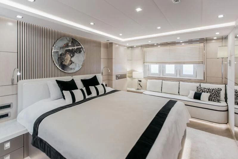 a large white bed with a round mirror above it aboard LEMANJA Yacht for Sale