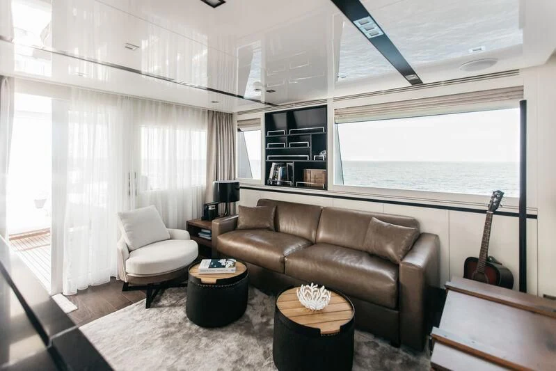 a living room with a leather couch and a guitar aboard LEMANJA Yacht for Sale