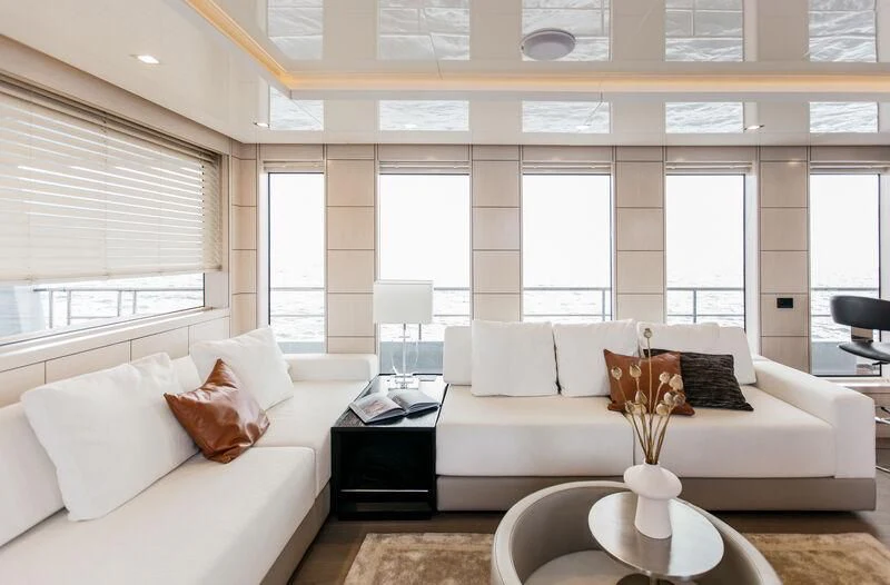 a living room with a white couch and a large window aboard LEMANJA Yacht for Sale
