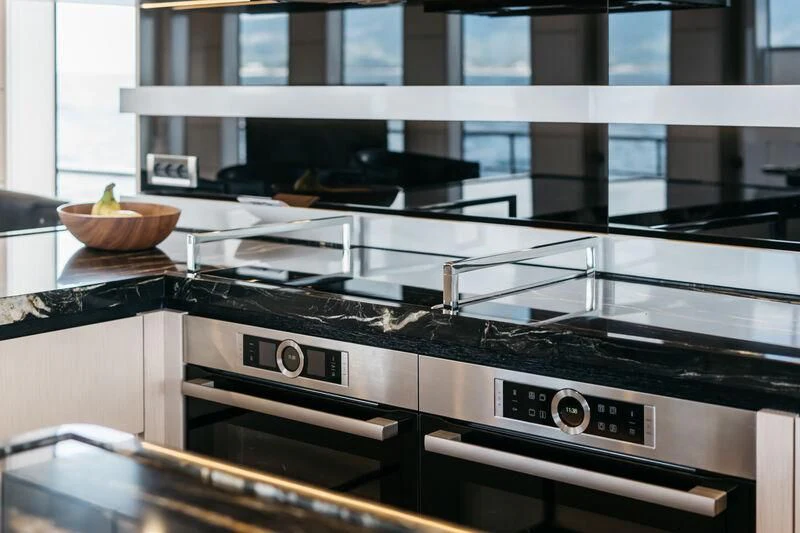 a kitchen with a stove and a bowl of fruit on the stove aboard LEMANJA Yacht for Sale